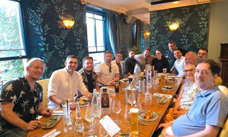 Retirement celebration with gifts, a framed team photograph and a congratulatory card