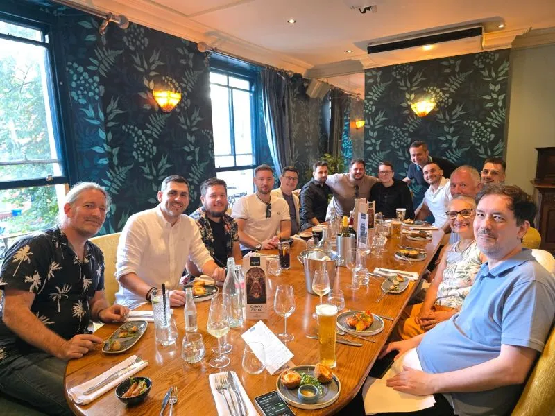 Retirement celebration with gifts, a framed team photograph and a congratulatory card