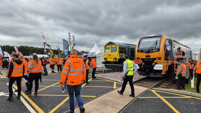 Visitors in high-visibility clothing beside locomotives at RailLIVE