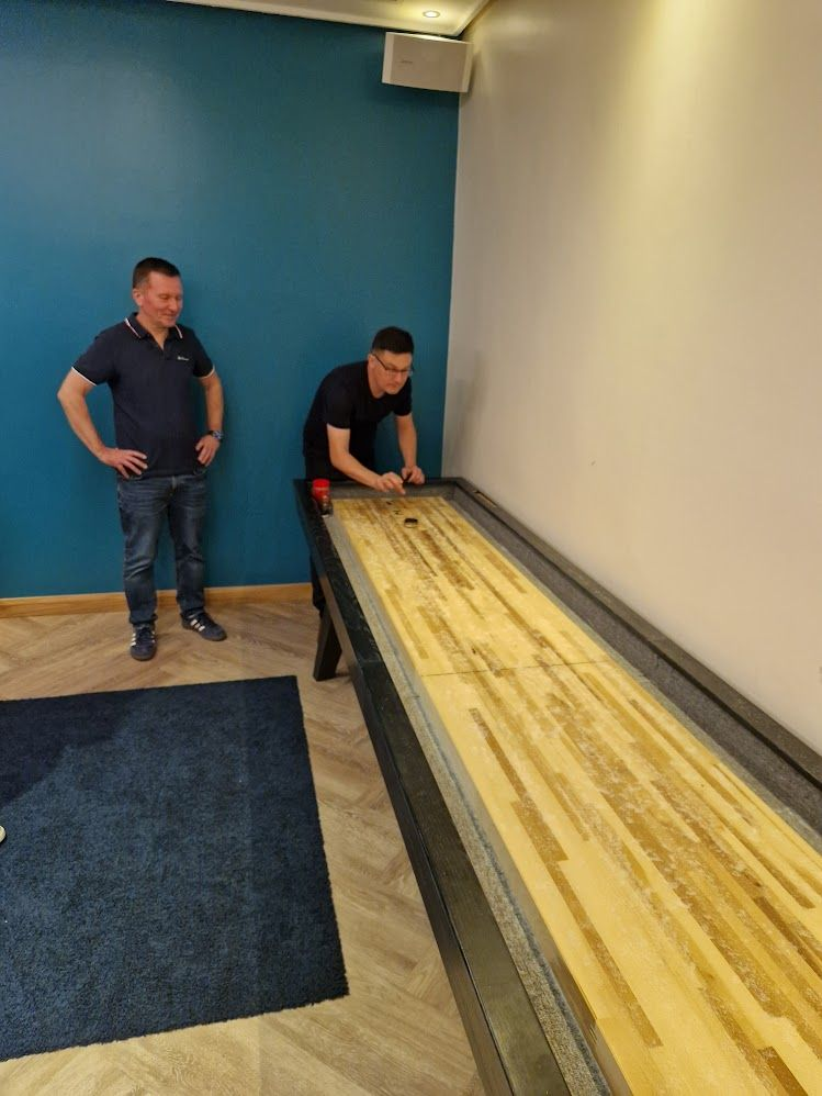 Colleagues playing table shuffleboard during the Vesta gathering